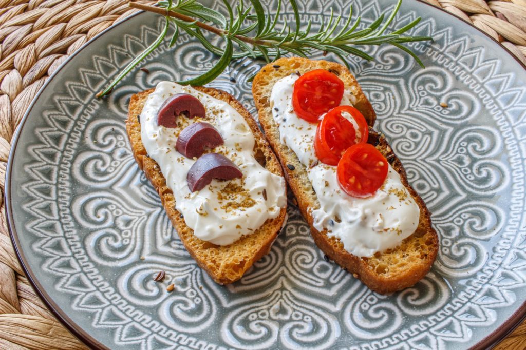 توست كروستيني - Crostini Toasts with Toasted Seeds and Labne with tomatoes & kalamata olives.