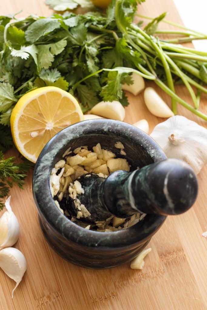 mashing garlic & salt in a mortar & pestle